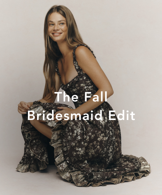 Smiling woman in a black floral bridesmaid dress sitting against a beige background with text "The Fall Bridesmaid Edit"