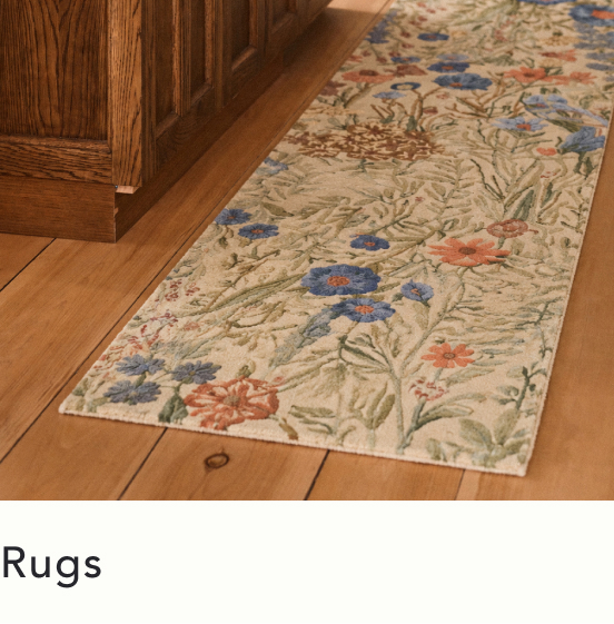 Floral patterned runner rug with blue and coral flowers on beige background, placed on hardwood floor next to oak cabinets