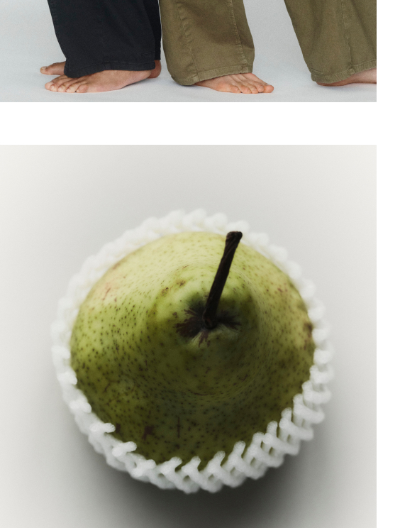 Three pairs of bare feet in pants - black, olive green, and khaki - standing on a white surface.