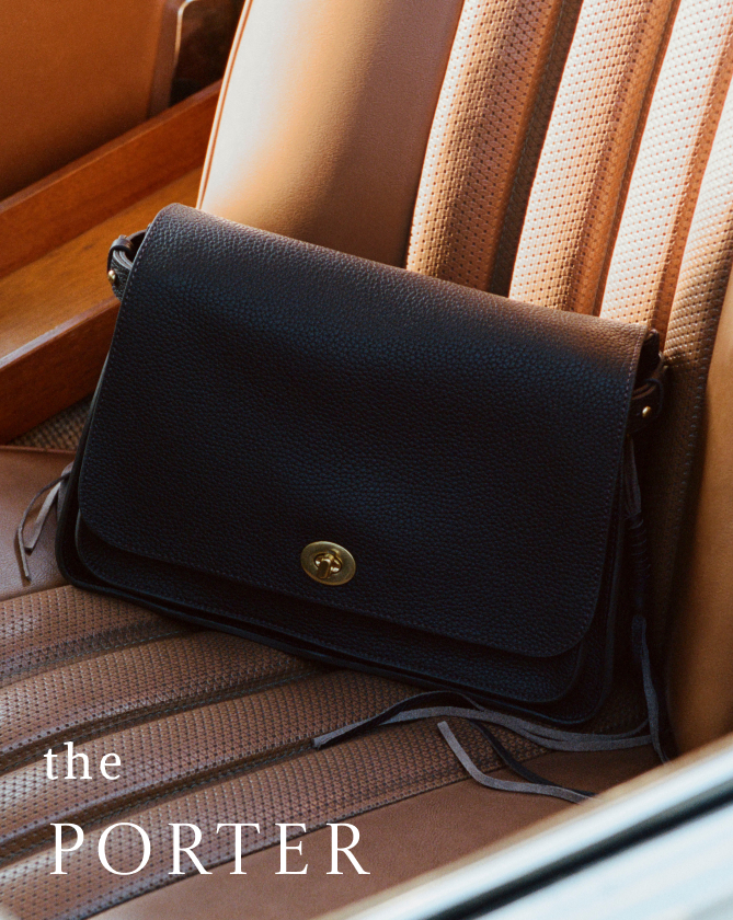 Black leather crossbody bag with brass button closure on striped chair with text "the PORTER" in white letters