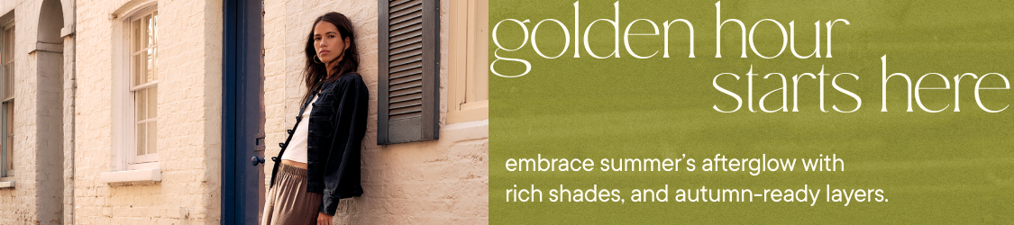Woman in black jacket and pleated skirt by building with text "golden hour starts here embrace summer's afterglow