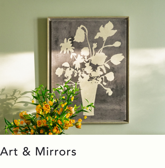 Framed floral artwork with gray background and cream silhouettes hangs on green wall above orange flowers with text Art & Mirrors