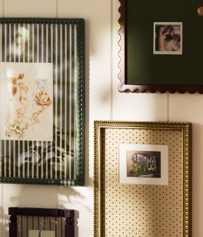 Four decorative picture frames with various patterns including stripes, polka dots, and scalloped edges displayed on a white wall.