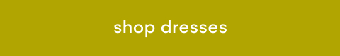 White text reading 'shop dresses' centered on a mustard yellow rectangular button background