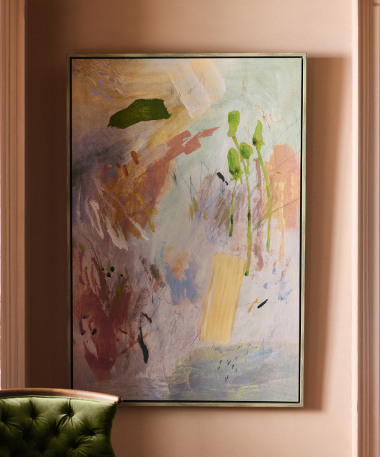 Sage green wooden mirror with decorative turned posts mounted on white wall above a console table with bottles and lamp