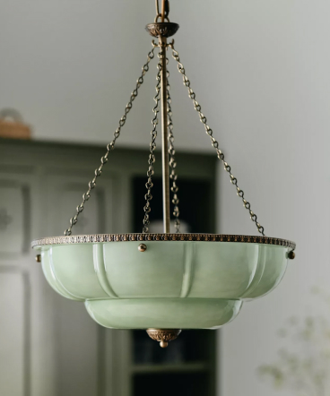 Vintage mint green glass bowl pendant light fixture suspended by brass chains against a white ceiling