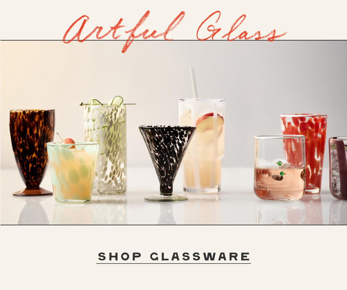 Artful Glass text above various decorative drinking glasses and cocktails on white surface with SHOP GLASSWARE text below