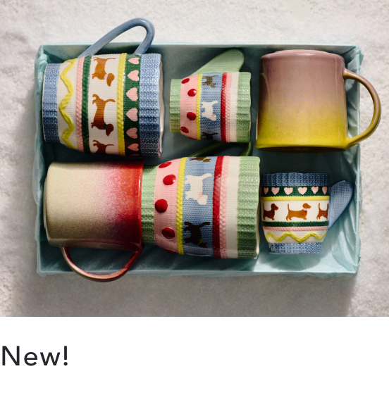 Four decorative ceramic mugs with colorful patterned bands and metal handles arranged in a light blue gift box with "New!" text below.