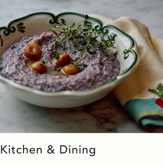 Purple hummus topped with microgreens and cherry tomatoes in a white bowl with green decorative rim on yellow napkin