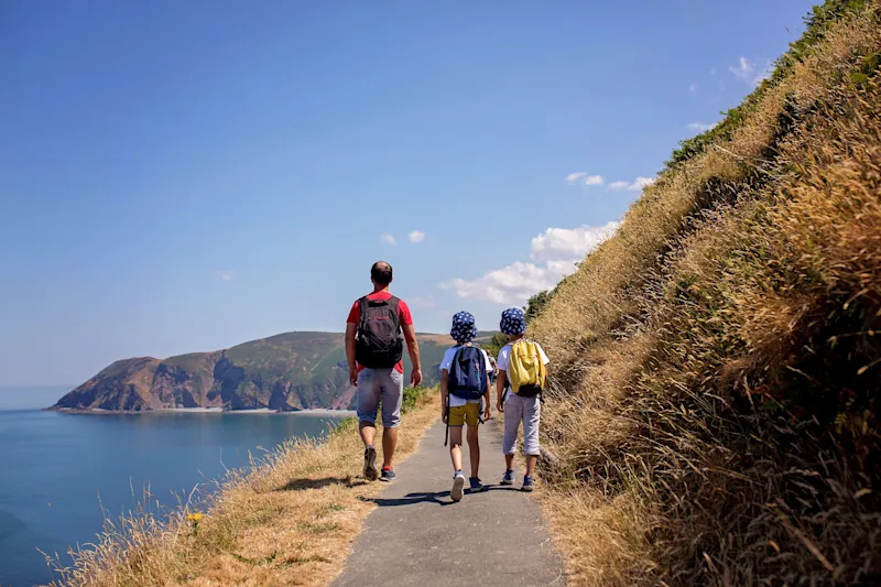 Family walking along the South West Coast Path near Lynmouth, North Devon, UK