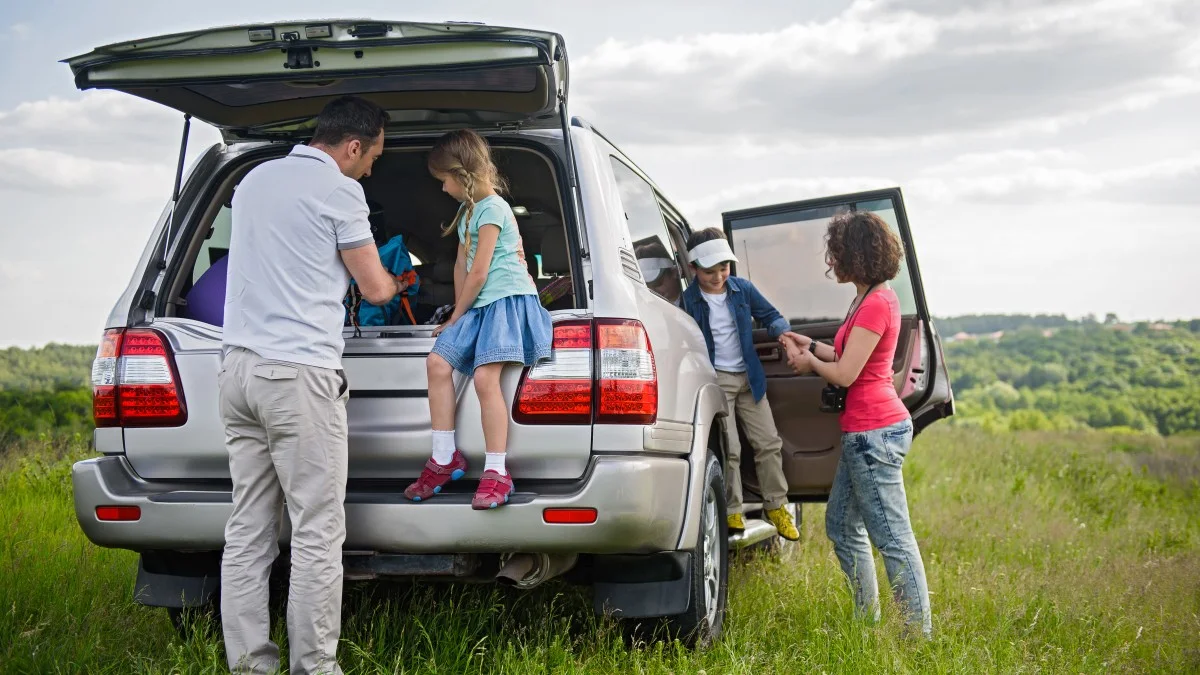 En familie tager en pause i sommerlandskabet under deres kør-selv ferie.