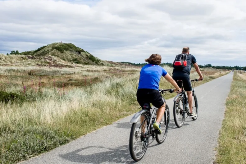 Eine Frau und ein Mann fahren Fahrrad in Blavand an der dänischen Westküste.