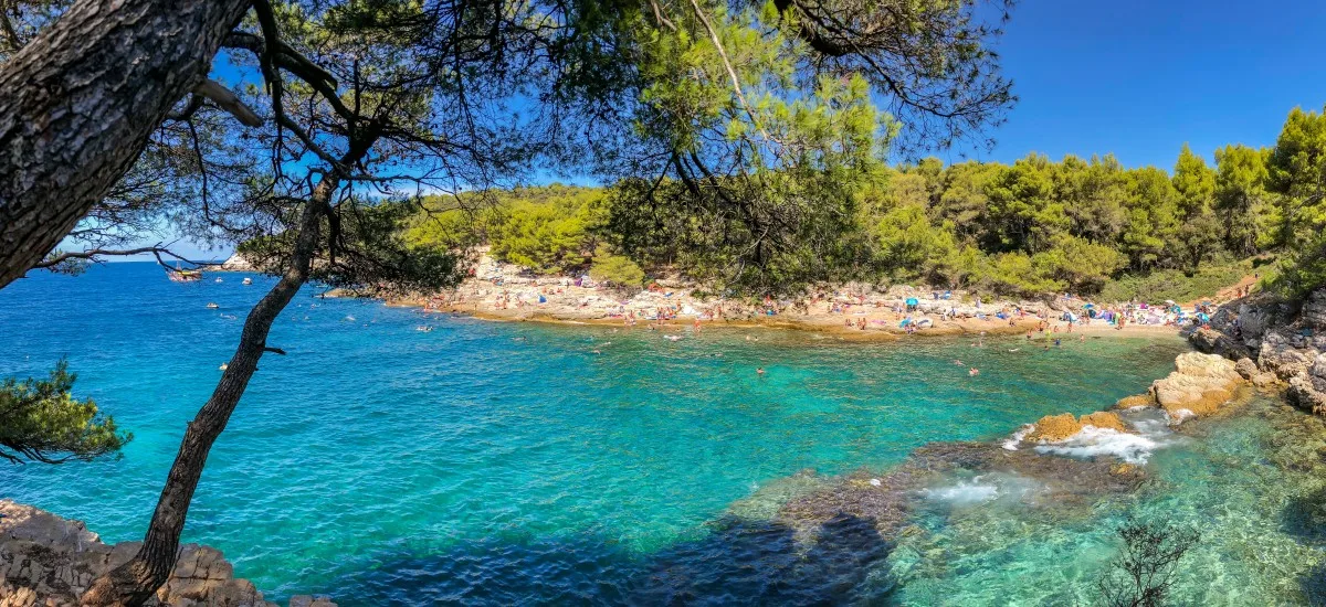 Felsige Bucht mit türkisblauem Meer an der Küste von Pula.