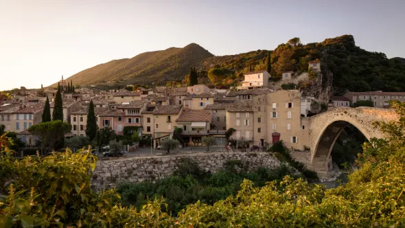 Udsigt over den historiske middelalderbro i Nyons over floden Eygues og de gamle bybygninger, Rhône-Alpes, Frankrig.
