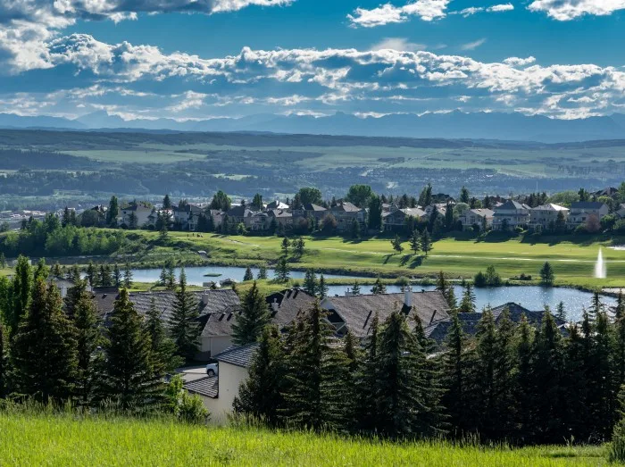 Overlooking a small Alberta town with the Glen Eagles Golf Course and distant Rocky Mountains.