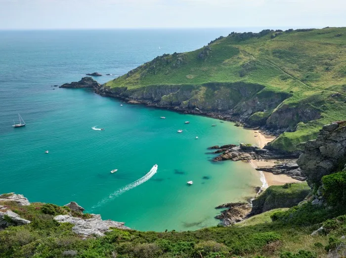 View towards Bolt Head across boats in Starehole Bay near Salcombe seen from the South West Coast Path, Devon,