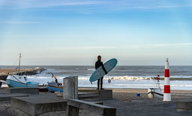 En surfer venter på at fange bølger i Cold Hawaii om vinteren, Nørre Vorupor og Klitmøller.