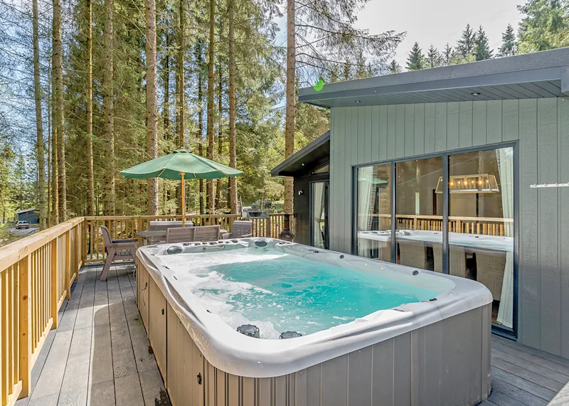 Hot tub lodge surrounded by trees at Kielder Waterside KILD) in Kielder Water and Forest Park, Northumberland, England, UK
