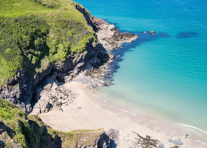 An isolated sandy beach on the beautiful unspoiled coastline between Polzeath and Port Isaac on a sunny day