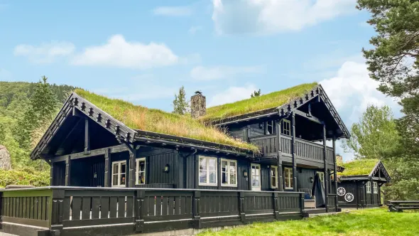 Zwart houten huis met een met gras bedekt dak in Noorwegen.