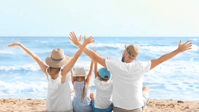 Happy family sitting on sea beach