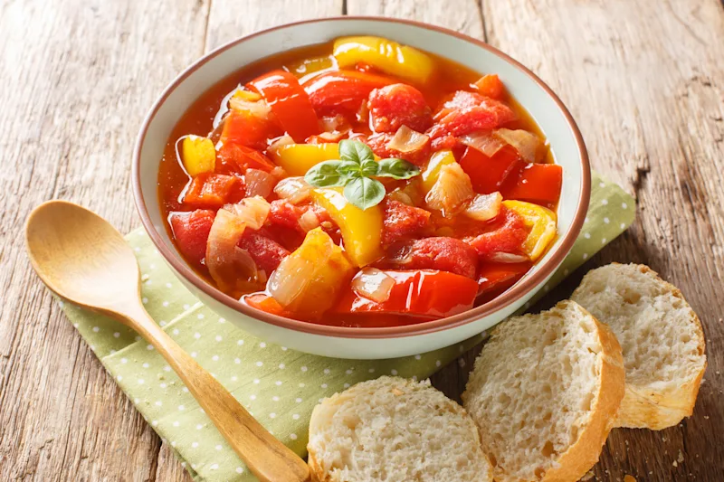 Hausgemachter Sataraš mit Paprika, Zwiebeln, Knoblauch und Tomaten in Nahaufnahme in einer Schüssel auf dem Tisch.