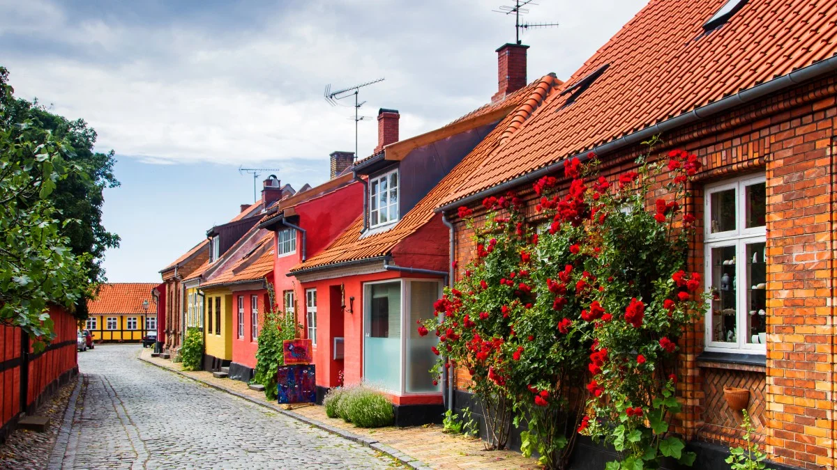 Brostenbelagt gade med farverige huse i Rønne på Bornholm.