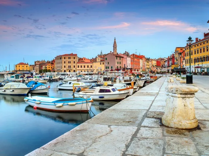 Blick auf einen kleinen Hafen mit Booten und einer Stadt in Istrien, Kroatien im Hintergrund.