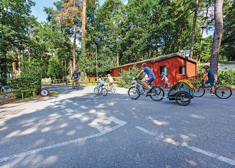 Family enjoying a bike ride at Sandy Balls Holiday Village (SABA) in Godshill, Fordingbridge, Hampshire, England, UK