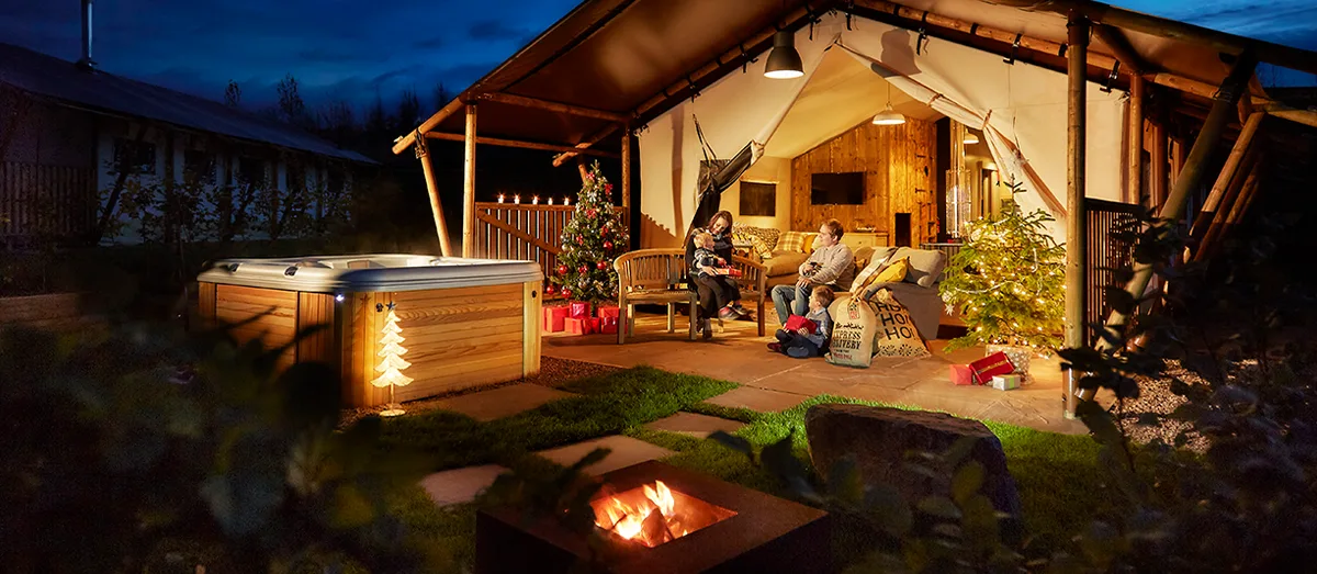 Family celebrating Christmas in a hot tub lodge