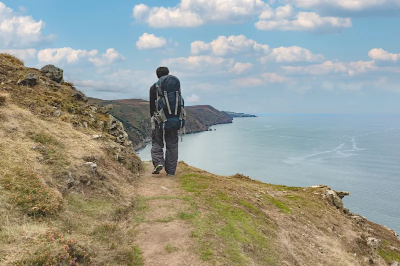 Hiker walking along the South West Coast Path near Combe Martin, North Devon, UK