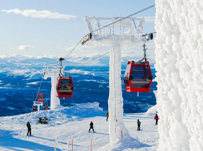  Skiområde i Sverige med frodige bjerge, sne og mennesker, der står på ski og nyder naturen.