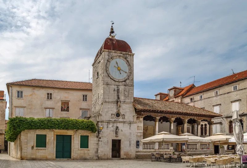 Historiske bygninger og kirke i den gamle bydel i Trogir på en solrig sommerdag.