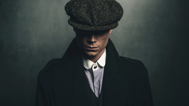 Mysterious portrait of retro 1920s english gangster with flat cap.