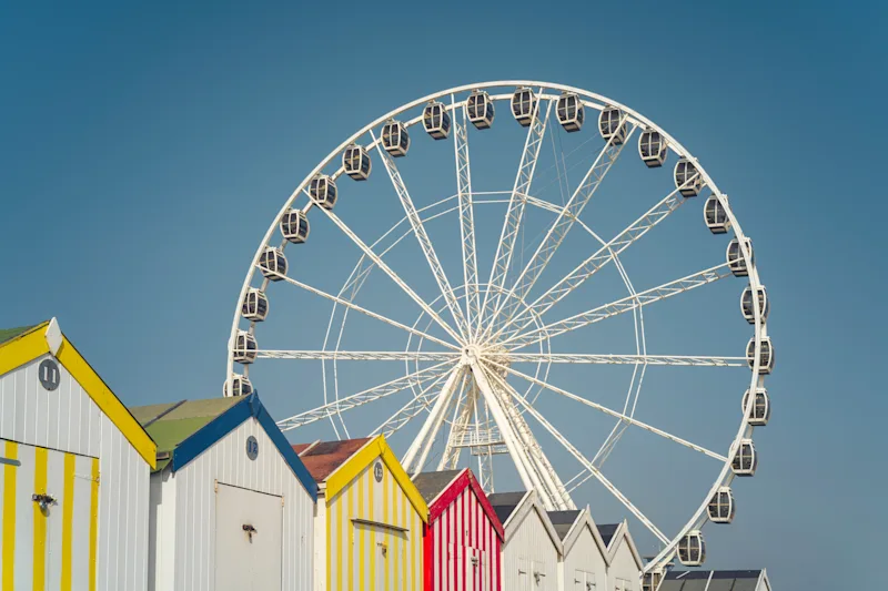 Ferris wheel and colourful beach huts on the beach at Great Yarmouth, Norfolk, England, UK