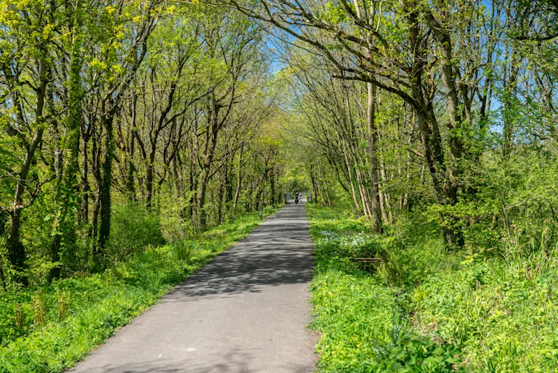 Couple cycling along the Tarka Trail in North Devon, UK