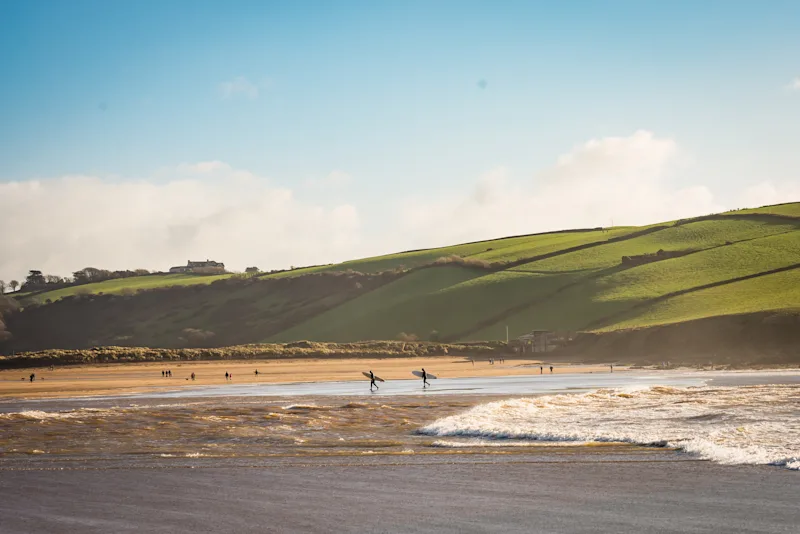 Surfers on Bigbury Beach at Burgh Island causeway, Bigbury-on-Sea, South Devon, UK