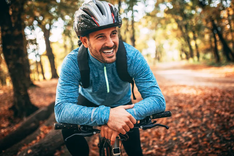 Young man biking through forest