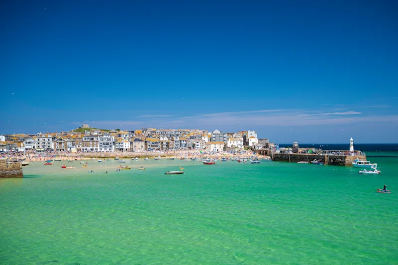 View of St Ives town and waterfront as seen from the sea on a sunny day with bue skies, in Cornwall, England, UK