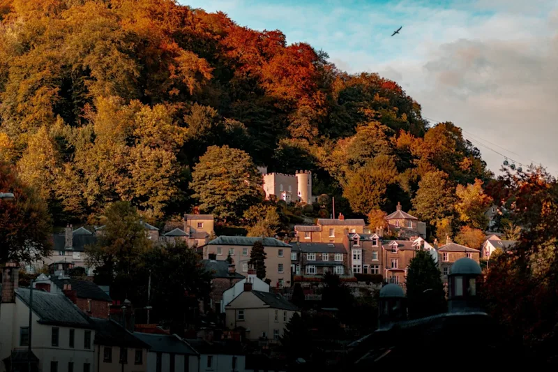 Forest view from Matlock with a castle in the orange trees during Autumn time with the town below.