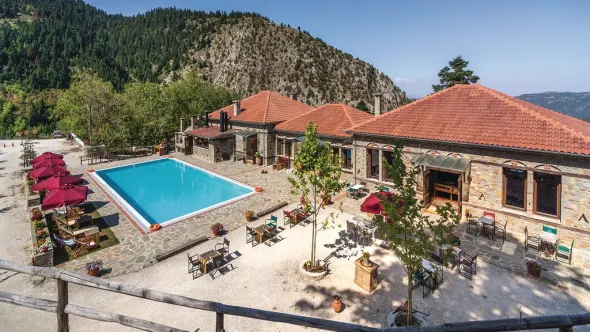 Villa met groot zwembad en terras in Griekenland. Bergen op de achtergrond.