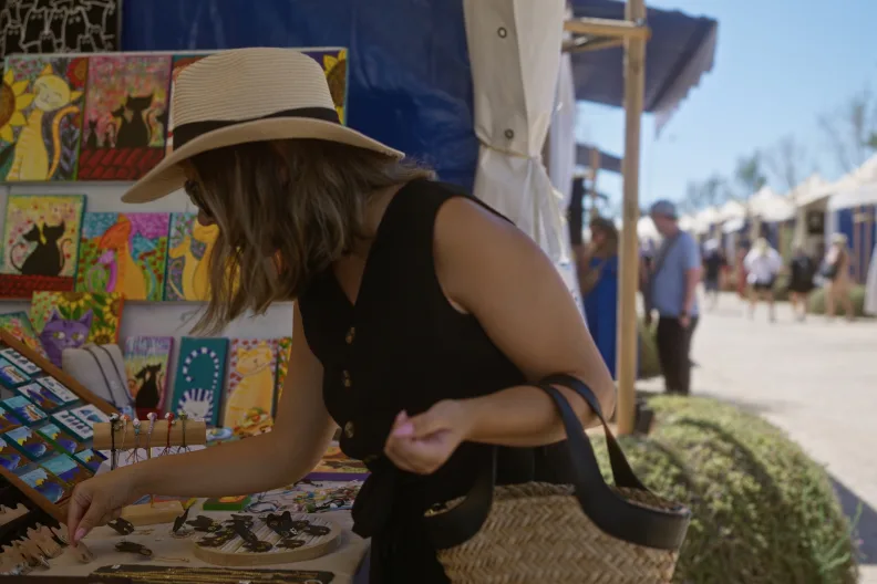Eine Frau mit Strohhut stöbert auf einem Markt auf Mallorca.