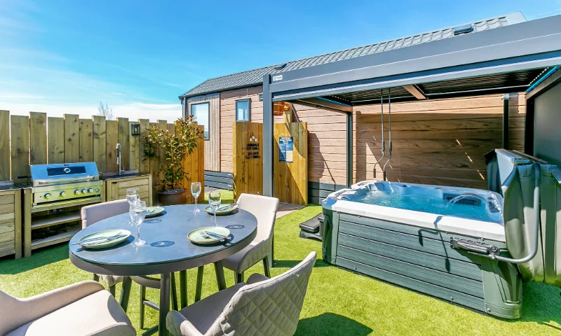 Set in the heart of rural Cornwall, The Nest combines boutique interiors with countryside calm – featuring soft linens, bifold doors, and a private deck with a hot tub for stargazing and slow mornings.