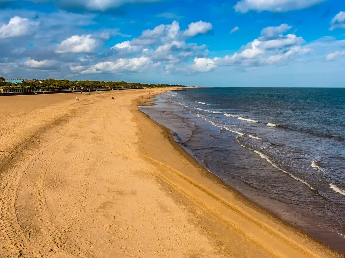 The view from Skegness pier, UK along the wide sandy beach in summertime