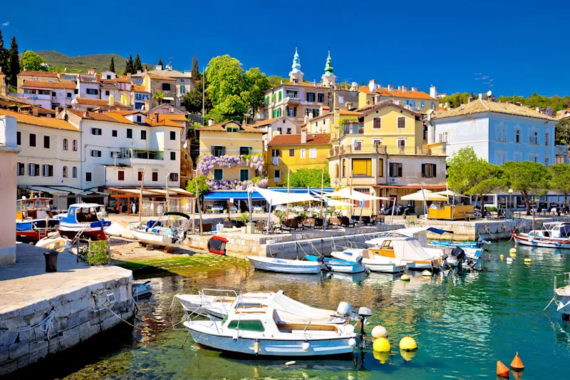 Havn med både og maleriske huse i baggrunden. Sommerstemning.