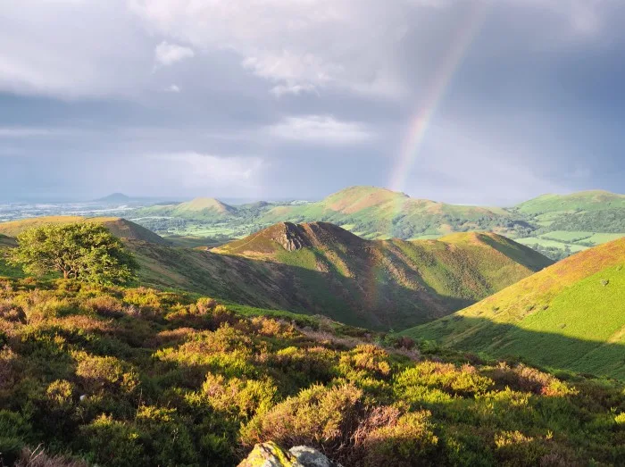 Scenic view of a rainbow on the green Long Mynd, Shropshire,