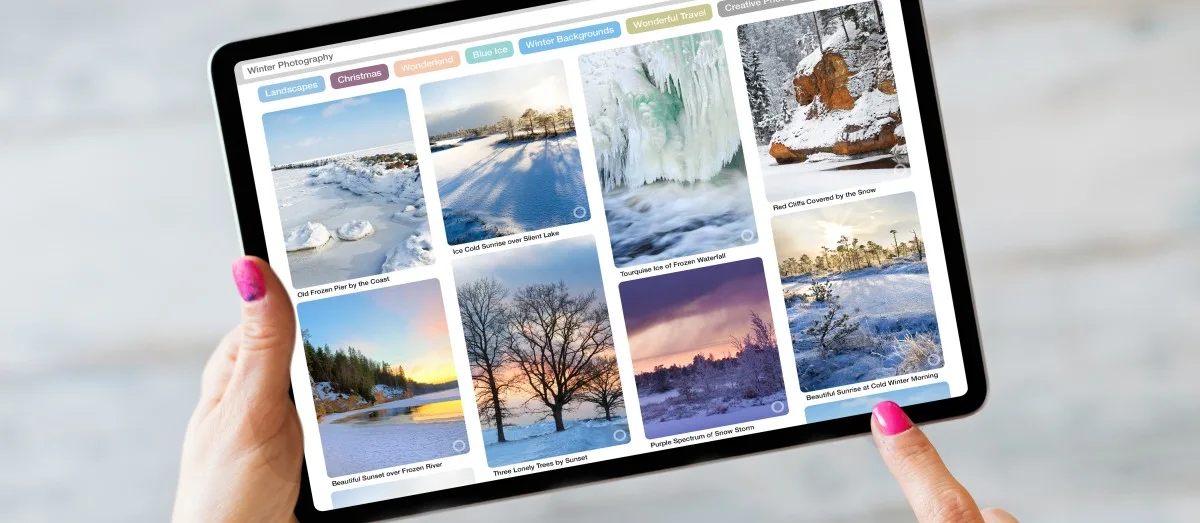 Woman using tablet and browsing beautiful winter photography online