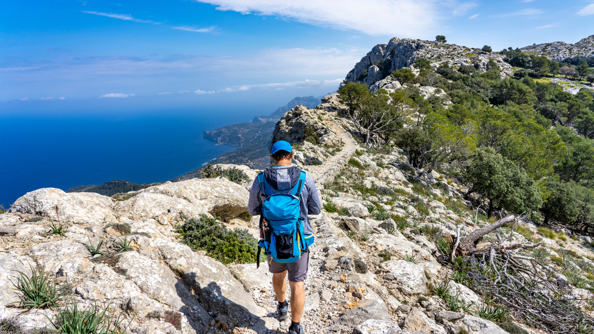 Wanderer mit Rucksack im Tramuntana Gebirge auf Mallorca.
