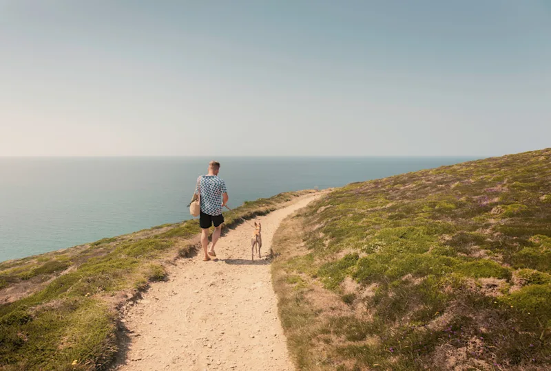 Dog walk along the South West Coast Path near Bedruthan Steps, Cornwall, UK