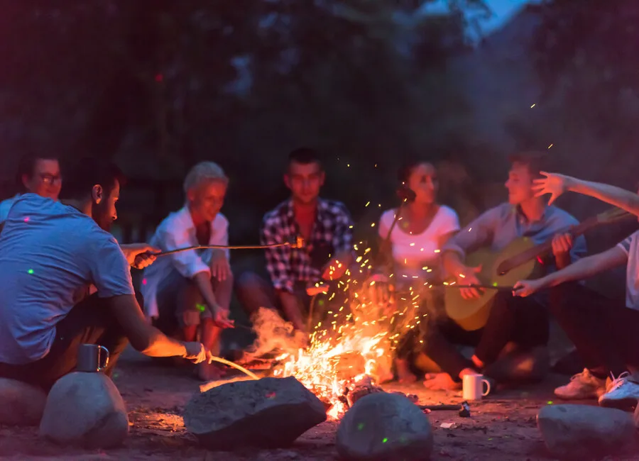 Menschen sitzen ums Lagerfeuer